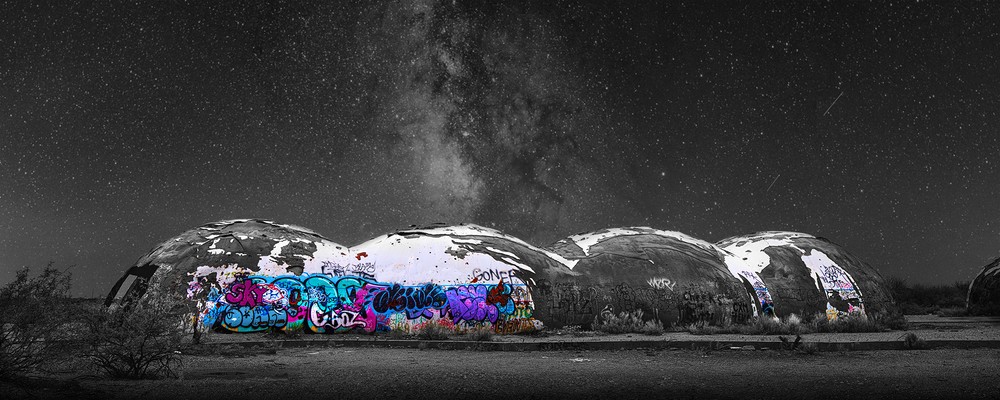 Graffiti-covered desert domes beneath the Milky Way