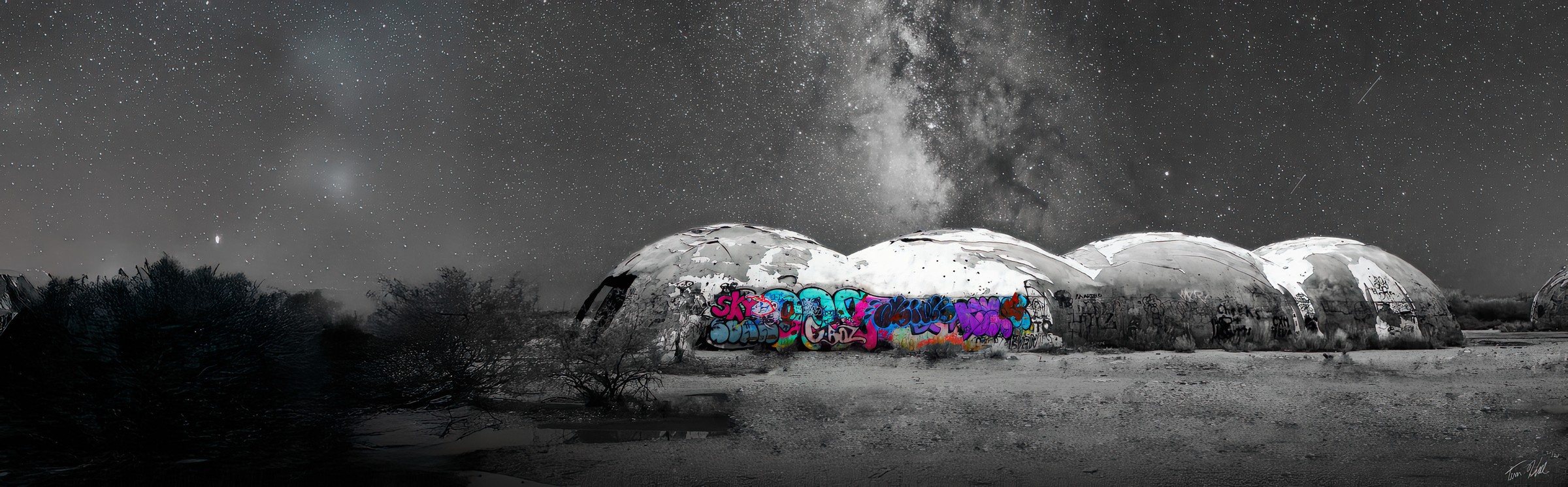 Panoramic desert domes with colorful graffiti under the Milky Way